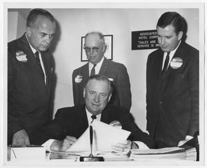 Primary view of object titled '[Photograph of Price Daniel Signing Documents with Men Looking On]'.