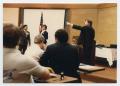 Photograph: [Photograph of Sam Chase Pointing to Group in Meeting]