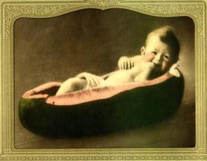 [Baby boy sitting in a cut out watermelon]