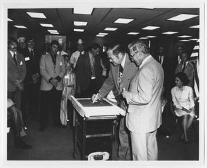 [Photograph of Governor Dolph Briscoe Signing Wet Concrete]