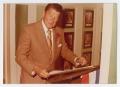 Photograph: [Photograph of Ronald Reagan With Document on Podium]