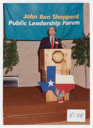 Primary view of object titled '[Photograph of George Greanias Standing at a Podium]'.