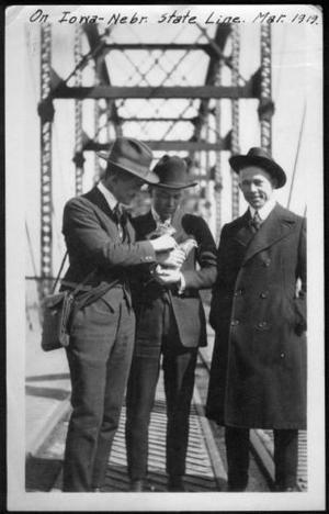 [Three men standing on a bridge at the Iowa-Nebraska state line]