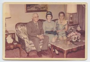 [Photograph of Three Unknown People Sitting on Couch]