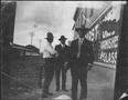 Thumbnail image of item number 1 in: '[Three men standing on a street sidewalk]'.