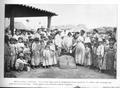 Thumbnail image of item number 1 in: '[Photograph of a large group of men, women, and children gathered around a huge pot of food]'.