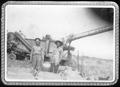 Photograph: [Two men standing near a rice thresher at the George Ranch]
