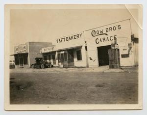 Primary view of object titled '[Photograph of Businesses Along a Dirt Road]'.