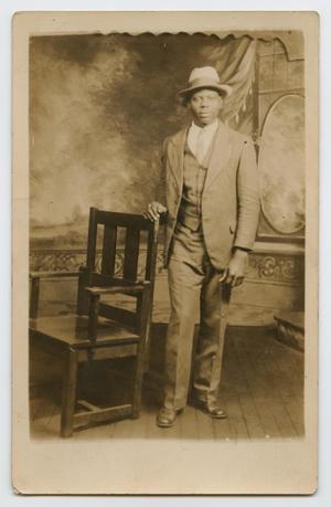 [Postcard Picturing an African-American Man Next to a Chair]