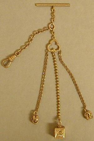 [Gold watch fob with a horizontal bar at the top]