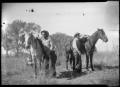 Photograph: [Photograph of Two Men and Two Horses]